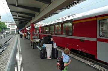 The Bernina Express leaves Tirano through the streets