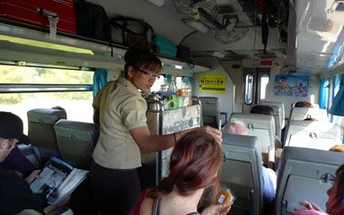 A hostess serves complimentary drinks and snacks on train 9 from Bangkok to Chiang Mai