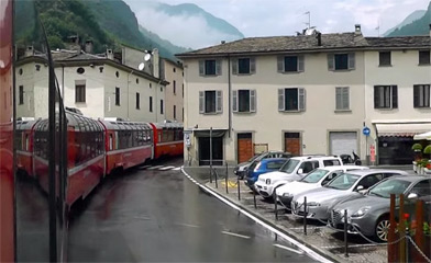 The Bernina Express leaves Tirano through the streets